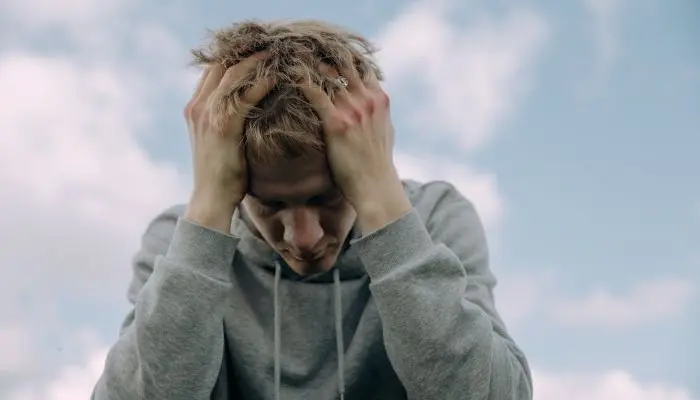 Anxious boy with head in his hands