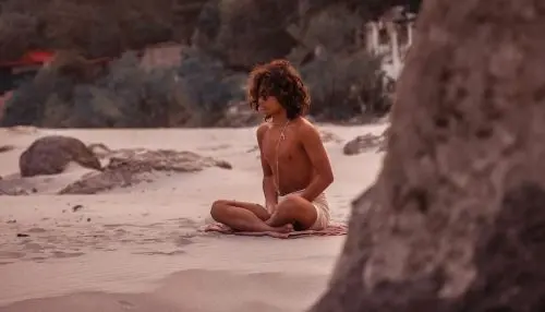Boy meditating on a beach